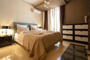 1 dormitorio con cama y ventana grande en Tbilisi Core 3BR Apartment in the heart of the city, en Tiflis