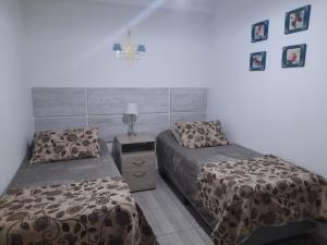 1 dormitorio con 2 camas y una cruz en la pared en Monseñor Fagnano 592 "5" en Ushuaia