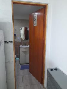 a bathroom with a wooden door and a sink at Monseñor Fagnano 592 "5" in Ushuaia