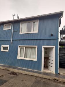 a blue house with a white door and a table at Monseñor Fagnano 592 "5" in Ushuaia