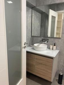 a bathroom with a white sink and a mirror at Lovely 2 bedroom apartment in South Lisbon in Barreiro