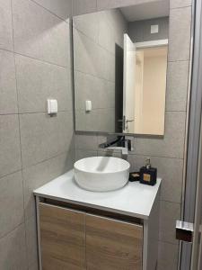 a bathroom with a white sink and a mirror at Lovely 2 bedroom apartment in South Lisbon in Barreiro