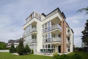 ein Apartmenthaus mit Balkonen und Tischen in der Unterkunft Objekte im Umland Seesand Nr 4 in Scharbeutz