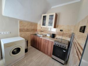 een keuken met een wasmachine en een wasmachine bij Klára Vendégház in Bük