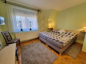 ein kleines Schlafzimmer mit einem Bett und einem Fenster in der Unterkunft Klára Vendégház in Bük