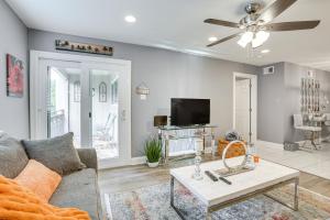 a living room with a couch and a tv at New Orleans Condo with Pool, 7 Mi to French Quarters in New Orleans