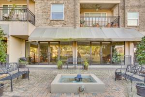 un patio con bancos y una fuente frente a un edificio en New Orleans Condo with Pool, 7 Mi to French Quarters, en Nueva Orleans