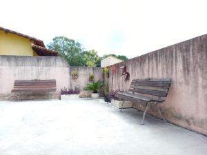dwie ławki siedzące obok betonowej ściany w obiekcie CASA DOS BONS VENTOS - À 6 minutos da praia de carro w mieście Itaipuaçu