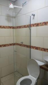 a bathroom with a shower with a toilet and a sink at Hotel Caçula São Gabriel in São Gabriel