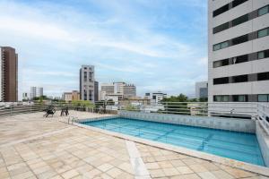a swimming pool on the roof of a building at Flat Metropoles Ilha do Leite by Easy Home in Recife