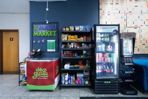 a store with a soda machine next to a soda cooler at Flat Metropoles Ilha do Leite by Easy Home in Recife