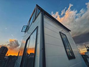 a building with glass windows with a sunset in the background at 枕木 New house with Huge View for Family-Group in Tokyo