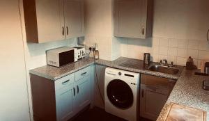 a kitchen with a sink and a washing machine at 11 Lygon Walk 