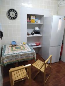 cocina con mesa, silla y nevera en Habitación hippie, en Cartagena