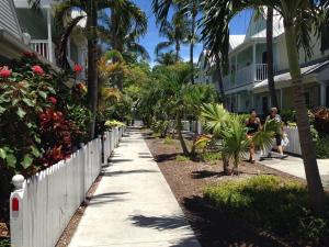 two people walking down a sidewalk in front of a house at Beautiful Downtown Truman Annex Condo in Key West