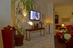 vestíbulo con chimenea y TV en la pared en Hotel Mediterraneo, en Chianciano Terme