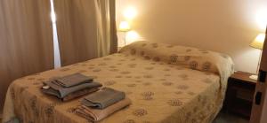 a hotel room with a bed with towels on it at Caleta Austral - dptos in Las Grutas