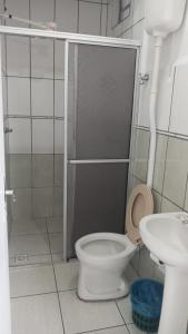 a bathroom with a toilet and a sink at Hotel Caçula São Gabriel in São Gabriel