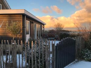 a wooden fence in front of a tiny house at Appartement in Meliskerke
