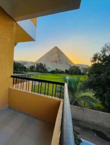 een uitzicht op de piramides vanaf het balkon van een gebouw bij Glamour Pyramids Hotel in Caïro