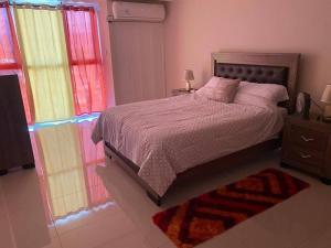 a bedroom with a bed and two windows at Condo with pool in Portmore in Portmore