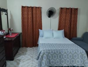 um quarto com uma cama e uma cómoda e cortinas em Diana's Portmore Retreat em Portmore
