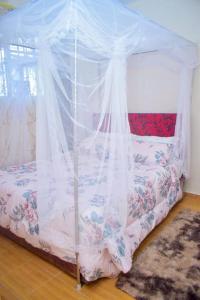1 cama con dosel en una habitación en Trinity Garden en Nairobi