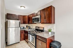 a kitchen with wooden cabinets and stainless steel appliances at Beautifully Furnished Studio Att Students Ilennox in Philadelphia