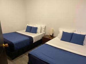 two beds in a room with blue and white at El solar casa hotel in Manizales