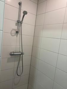 een douche met een douchekop in de badkamer bij City Appartement with Private free parking in Enschede
