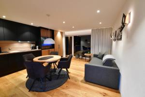 eine Küche und ein Wohnzimmer mit einem Sofa und einem Tisch in der Unterkunft Ferienwohnungen Kohler komplett neu renoviert !!!!! in Mittelberg