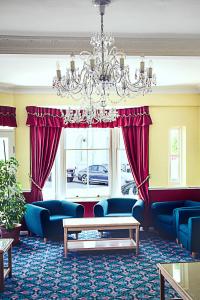 a living room with blue furniture and a chandelier at Afton Hotel in Eastbourne