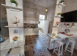 - une cuisine avec des placards blancs, une table et des chaises dans l'établissement Hostel El Español, à Saint-Domingue