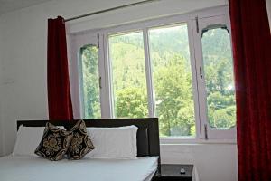 1 dormitorio con 1 cama y ventana grande en Piece Of Paradise Bhaderwah en Bhadarwāh