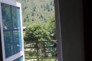 una ventana abierta con vistas a la montaña en Piece Of Paradise Bhaderwah en Bhadarwāh