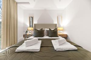 a bedroom with a large bed with towels on it at Atlas House Five in Harrogate