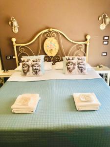 a bed with two towels and a clock on it at B&B Giulia in Taormina