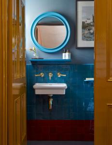 a bathroom with a sink and a mirror at Suites @ The Townhouse by designer Tobias Vernon in Bath