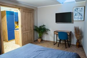 a bedroom with a bed and a desk and a television at Pokoje Siódemka in Stegna