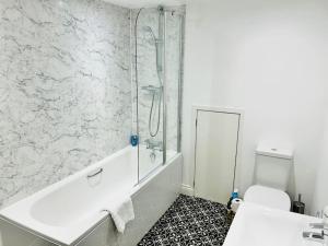 een badkamer met een douche, een bad en een toilet bij Cowpasture Apt - Ilkley Central in Ilkley