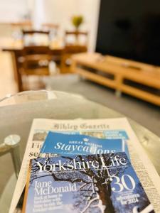 een krant bovenop een tafel bij Cowpasture Apt - Ilkley Central in Ilkley