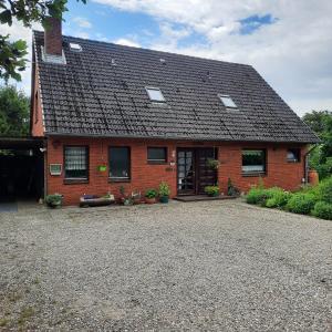 a red brick house with a black roof at Kulumheide 