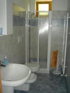 een badkamer met een douche, een wastafel en een toilet bij Appartement in San Zeno Di Montagna mit Terrasse und Garten und Seeblick in San Zeno di Montagna