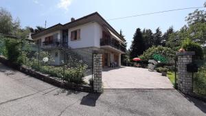 een huis met een hek en een oprit bij Appartement in San Zeno Di Montagna mit Terrasse und Garten und Seeblick in San Zeno di Montagna