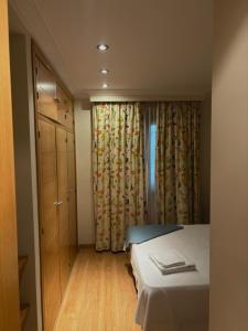 1 dormitorio con 1 cama, vestidor y cortinas en GAV Mondragón en Ronda
