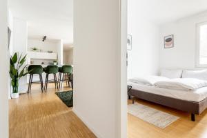 Global Living - Design Apartment I Central I Smart-TV I Kitchen I Berlin في برلين: غرفة نوم مع سرير وغرفة طعام