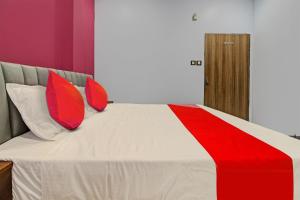 Una cama con almohadas rojas y blancas. en OYO Flagship Rr Lodging And Boarding, en Itwāri