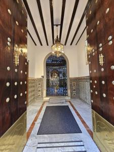 un corridoio con una grande porta e una stanza con un tappeto di Casona de San Andrés a Siviglia