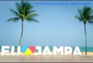 un cartello sulla spiaggia con due palme di •Incrível suíte com: acesso totalmente individual! a João Pessoa