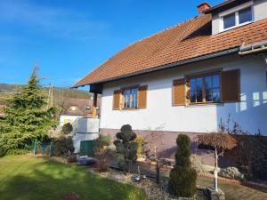 Casa blanca con ventanas marrones y patio en Zwei Schlafzimmer Ferienapartment Anna am Stubenbergsee, en Stubenberg